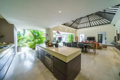an open kitchen and living room with an island in the middle at Exquisite 4BD Luxury Villa in the Heart of Berawa in Canggu