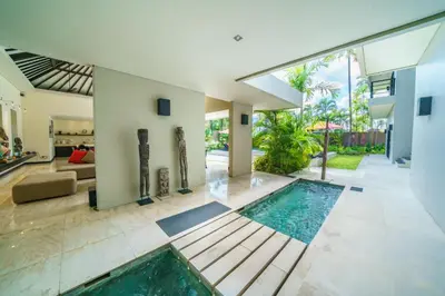 an open living room with a swimming pool in a house at Exquisite 4BD Luxury Villa in the Heart of Berawa in Canggu