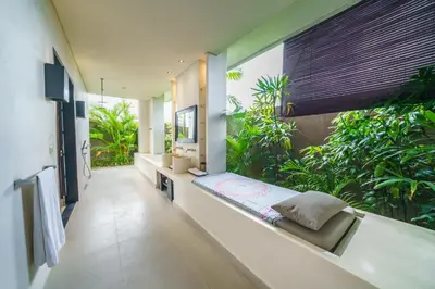 a large bathroom with a bench and plants at Exquisite 4BD Luxury Villa in the Heart of Berawa in Canggu