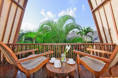 a porch with two chairs and a table on a balcony at LataLiana Seminyak in Seminyak