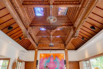 a room with a wooden ceiling and windows at LataLiana Seminyak in Seminyak