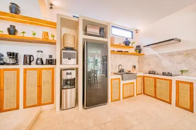 a kitchen with orange and white walls and wooden cabinets at Villa San Diego: Brand New 4BDR in Seminyak