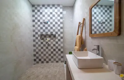 a bathroom with a sink and a checkered wall at Simple & Magical Villas Almaya 2 in Canggu