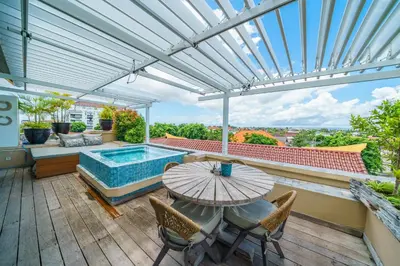a patio with a table and a swimming pool at Private Penthouse with Sunset Views Central Seminyak in Seminyak