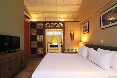 a bedroom with a large white bed and a television at Private Penthouse with Sunset Views Central Seminyak in Seminyak