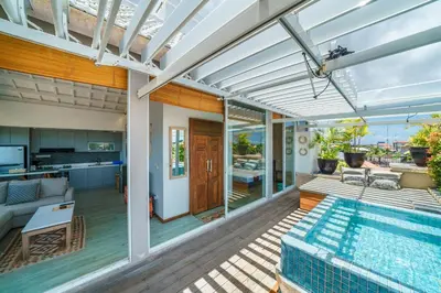 a patio with a swimming pool and a house at Private Penthouse with Sunset Views Central Seminyak in Seminyak