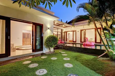 a villa with a garden and a swimming pool at Villa O'Anne in Seminyak
