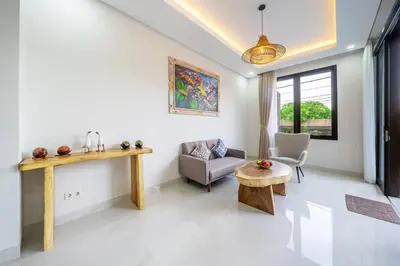 a living room with a table and a chair at TC Villa Taman Mumbul Nusa Dua in Nusa Dua