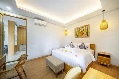 a bedroom with a bed and a table and a desk at TC Villa Taman Mumbul Nusa Dua in Nusa Dua