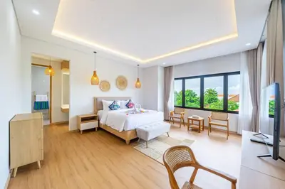 a bedroom with a bed and a living room at TC Villa Taman Mumbul Nusa Dua in Nusa Dua