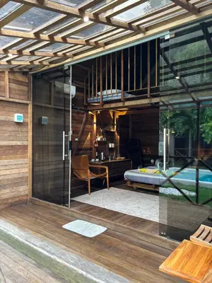 a room with a bed and a glass door at Bali Cozy Bungalows, Nusa Dua Benoa in Nusa Dua