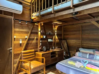 a bedroom with a bed and a desk and a chair at Bali Cozy Bungalows, Nusa Dua Benoa in Nusa Dua