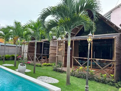 a house under construction with a pool and palm trees at Bali Cozy Bungalows, Nusa Dua Benoa in Nusa Dua