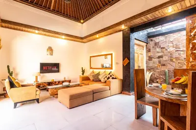 a living room with a stone wall at PROMO DEAL Sweet Unique Hidden Gem 2 BD Villa - CONSTRUCTION NEARBY in Kerobokan