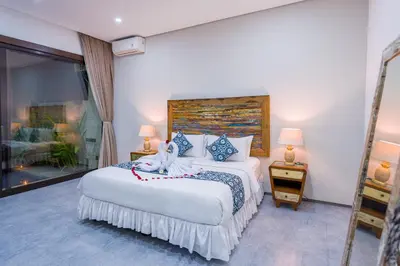 a bedroom with a large bed and a large window at Villa Emilia Seminyak by Nagisa Bali in Kerobokan