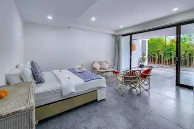 a bedroom with a bed and a table and chairs at Villa Emilia Seminyak by Nagisa Bali in Kerobokan
