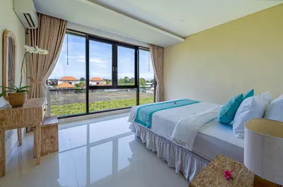 a bedroom with a bed and a large window at Villa Emilia Seminyak by Nagisa Bali in Kerobokan