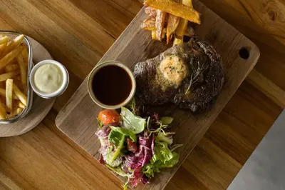a plate of food with a steak and salad and french fries at Two-Bedroom Pool Villa at Anwa Residences in Canggu