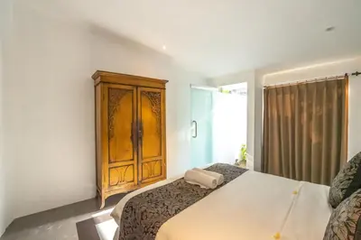 a bedroom with a bed and a wooden cabinet at 5 Bedroom Villa Etnik in Seminyak with Big Garden and Private Pool in Seminyak
