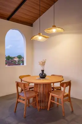 a dining room with a wooden table and chairs at Mysa Boutique Hotel in Seminyak