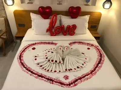 a heart shaped cake on a bed with the word love at Mysa Boutique Hotel in Seminyak