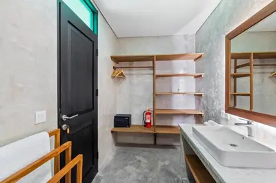 a bathroom with a sink and a black door at Abu Villa by Betterplace in Canggu