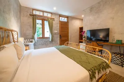 a bedroom with a large bed and a television at Little Boutique Hotel No 101 in Canggu
