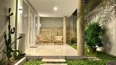 a patio with a table and chairs on a house at Mila's Villa in Legian