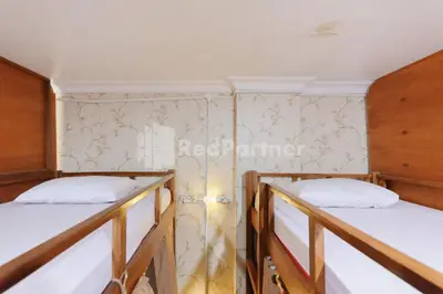 two bunk beds in a room with a wall at Shooting Star Hostel Kuta RedPartner - mixed dormitory in Legian