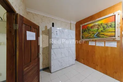 a room with a door and a painting on the wall at Shooting Star Hostel Kuta RedPartner - mixed dormitory in Legian