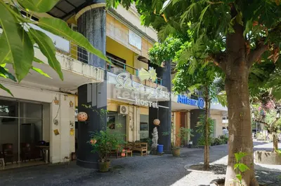 a building with a tree in front of it at Shooting Star Hostel Kuta RedPartner - mixed dormitory in Legian