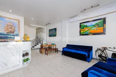a living room with a blue couch and a table at Shooting Star Hostel Kuta RedPartner - mixed dormitory in Legian