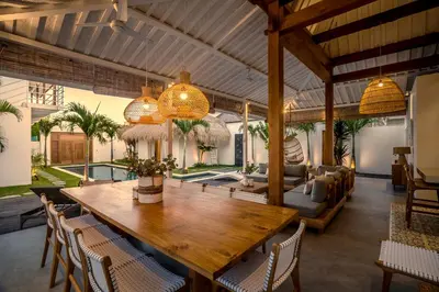 a dining room with a wooden table and chairs at Villa Makena by Alfred in Bali in Seminyak