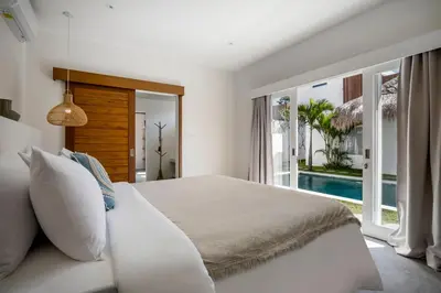 a bedroom with a large bed and a swimming pool at Villa Makena by Alfred in Bali in Seminyak