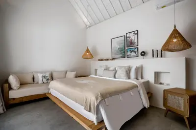 a bedroom with a large bed and a couch at Villa Makena by Alfred in Bali in Seminyak