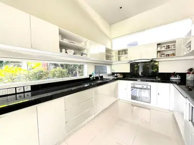 a kitchen with white cabinets and a large window at Villa Plawa in Seminyak