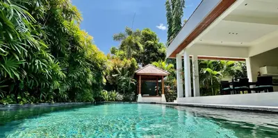 a swimming pool in front of a house with a gazebo at Villa Plawa in Seminyak