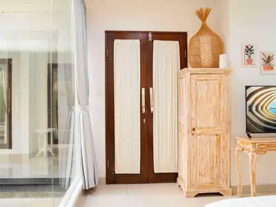 a living room with a wooden door and a cabinet at Villa between seminyak & canggu in Seminyak