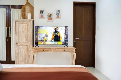 a bedroom with a television on a wooden stand at Villa between seminyak & canggu in Seminyak