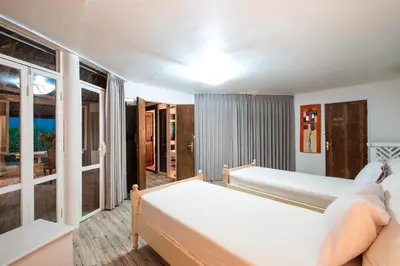 a bedroom with two beds and a window at Seminyak Villa Kubuku in Seminyak
