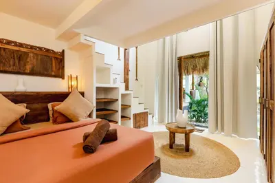 a bedroom with a orange bed and a table at Villa Micasa - Tropical Oasis 4BR Villa with Private Pool, Perfect for Big Groups, 12 Minutes to the Beach in Kerobokan