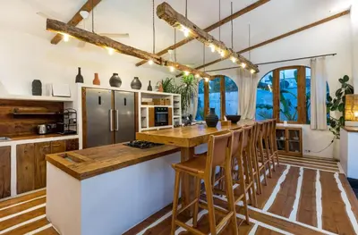 a kitchen with a wooden counter top and wooden stools at Villa Micasa - Tropical Oasis 4BR Villa with Private Pool, Perfect for Big Groups, 12 Minutes to the Beach in Kerobokan