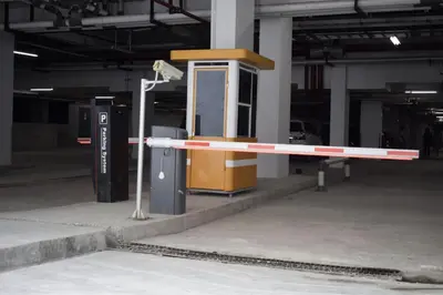 a barrier in a parking lot with a phone booth at Anagata 3 Tanjung Benoa Bali in Nusa Dua