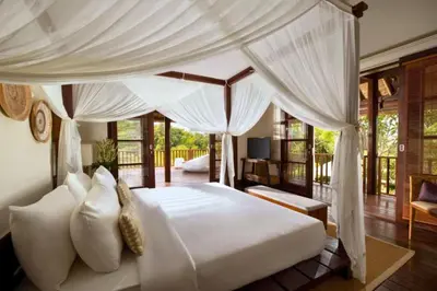 a bedroom with a large white bed with curtains at Mandevilla 4 BR Private Pool Villa NE25 in Jimbaran