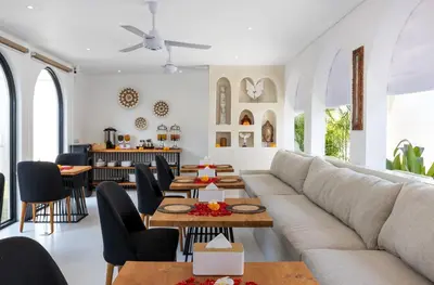 a living room with a couch and tables and chairs at Villa Kelolyne in Seminyak
