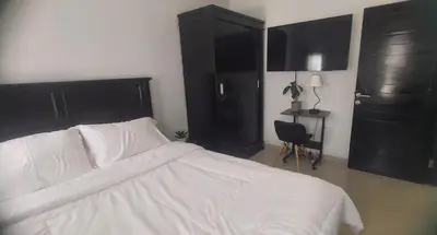 a bedroom with a white bed and black cabinets at Chandra's guest house in Pesanggaran