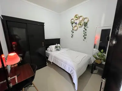 a bedroom with a bed and a black cabinet at Chandra's guest house in Pesanggaran