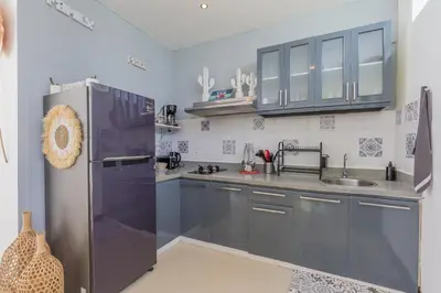 a kitchen with blue cabinets and a stainless steel refrigerator at Cosy 3 BR villa with private pool in Seminyak in Seminyak