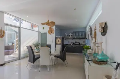 a dining room and kitchen with a glass table and chairs at Cosy 3 BR villa with private pool in Seminyak in Seminyak