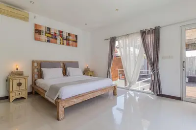 a bedroom with a bed and a large window at Cosy 3 BR villa with private pool in Seminyak in Seminyak